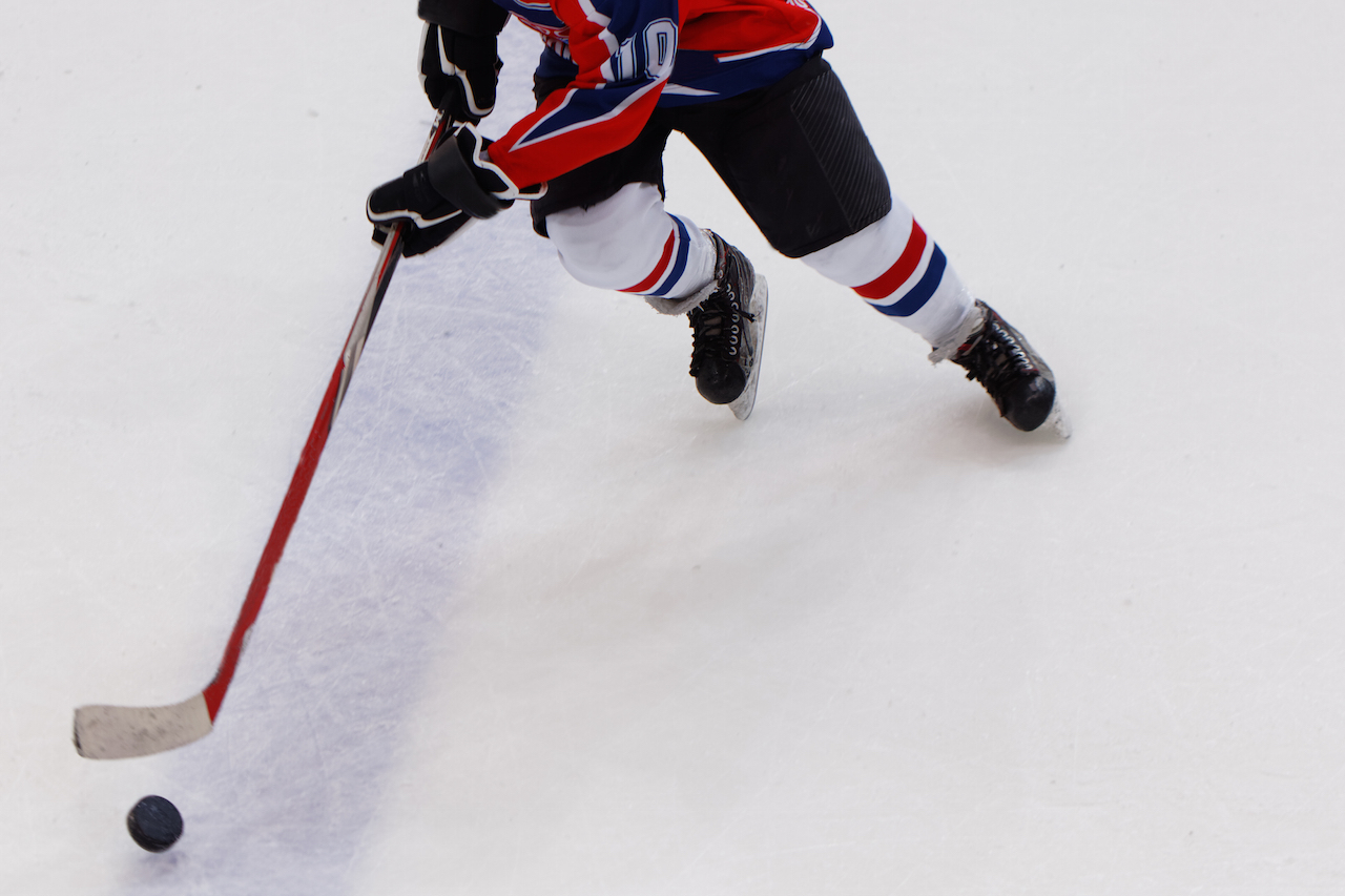 Хоккейный игрок с клюшкой на льду